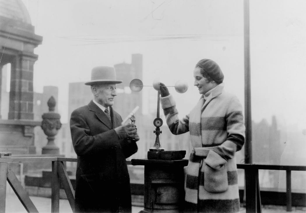 Meteorologist Ulysses G. Purssell, in charge of the U.S. Weather Bureau's Minneapolis office, and an unnamed woman were photographed alongside the cup-style anemometer atop the federal building in 1931.