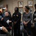 Michelle Gross, president of Communities United Against Police Brutality, standing with a walker, spoke Monday night at a news conference outside the 