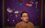 Visual artist Ger Xiong in his Minneapolis home and studio. The tapestry depicts his hometown of Appleton, Wis. 