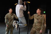 Staff Sgt. Terry Hong, left, recruiter for the Minnesota National Guard, and Zack Smith watched student Marshaun Steele, do pull-ups at Washington Tec