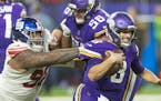 Minnesota Vikings quarterback Kirk Cousins (8) barely breaks the grasp of New York Giants defensive tackle Dexter Lawrence (97) during the fourth quar