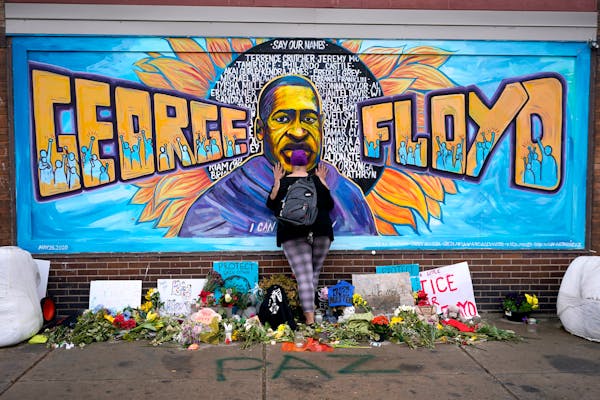Damarra Atkins pays respect to George Floyd at a mural at George Floyd Square in Minneapolis, April 23, 2021. 