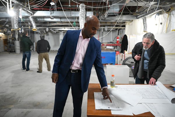 CEO Jamez Staples looks over building blueprints during a tour of the under-construction Renewable Energy Training Center.