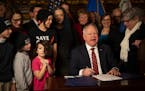 Minnesota Gov. Tim Walz signs one of the copies of the federal tax conformity bill on Jan. 12 at the State Capitol in St. Paul.