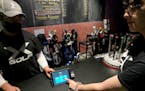 X-Golf manager J.W. Park, left, helps Ashley Moreno to check out at X-Golf indoor golf in Glenview, Ill., Friday, Jan. 20, 2023.