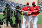 Minnesota Twins’ Nelson Cruz and Miguel Sano, right, hold the Bomba award presented to them by members of the Minneapolis Police bomb squad in 2019.