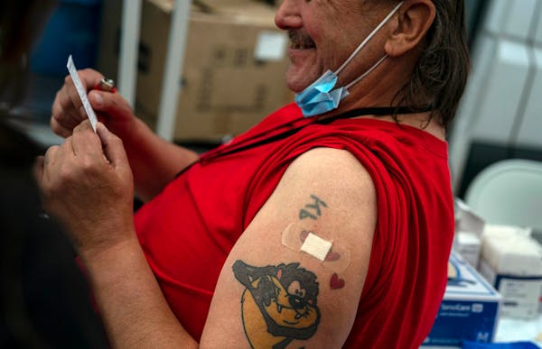 Kenneth Bennett, 54, holds his vaccination card after receiving a dose of COVID-19 vaccine at a mobile vaccination site in Seattle on May 17, 2021. 