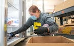 Dawn Williams, a volunteer, stocked a freezer with pork last week at the Southern Anoka Community Assistance Food Shelf in Columbia Heights..