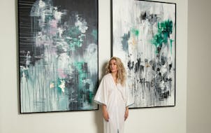 Sarah Edwards posed beside her paintings at the Chambers Hotel in Minneapolis, where she’ll host Sonder, an artist takeover of the hotel.