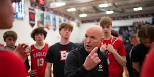 David Flom talked to his Eden Prairie team during a timeout Tuesday in his first game back after reinstatement.