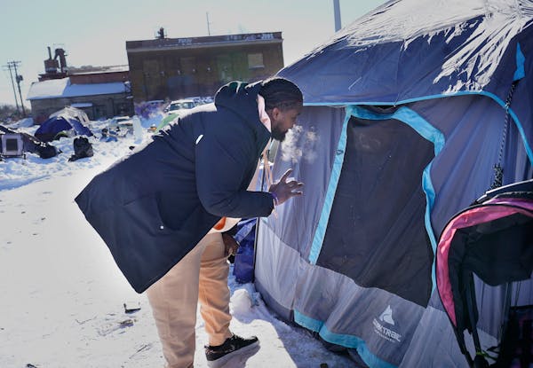 A housing access coordinator for the social services organization the Housing Guy talked to a resident of a homeless encampment in south Minneapolis o