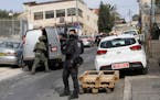 An Israeli policeman secures a shooting attack site in east Jerusalem, Saturday, Jan. 28, 2023.