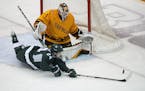 Michigan State out-shot the Gophers in the first period. Here, Gophers goalie Justen Close stopped a shot by Michigan States Erik Middendorf 