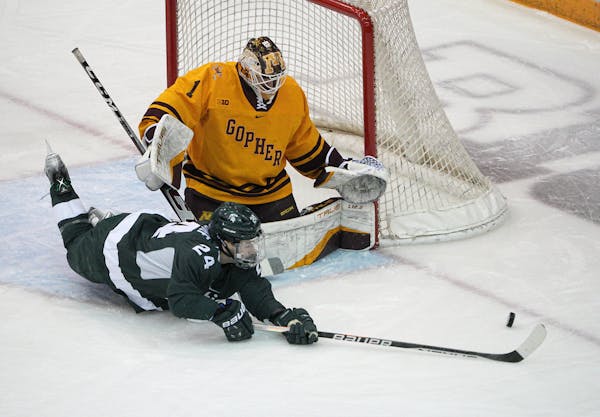 Michigan State outshot the Gophers in the first period. Here, Gophers goalie Justen Close stopped a shot by Michigan State’s Erik Middendorf.