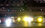 Cars race through a horseshoe turn during the Rolex 24 hour race at Daytona International Speedway on Saturday
