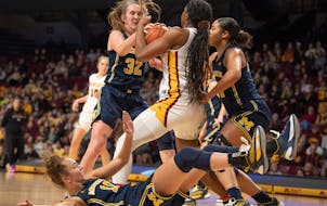 Michigan guard Leigha Brown (32) battled the Gophers’ Rose Micheaux (4) for a rebound in the first half at Williams Arena on Sunday.