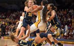 Michigan guard Leigha Brown (32) battled the Gophers’ Rose Micheaux (4) for a rebound in the first half at Williams Arena on Sunday.