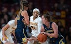 Michigan Wolverines guard Leigha Brown (32) dribbled pass Minnesota Gophers guard Mi'Cole Cayton (21) in the first half.