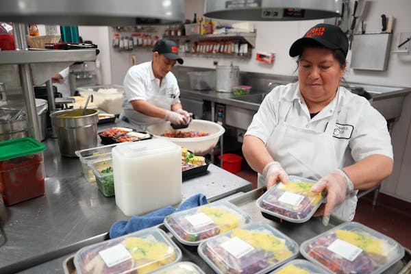 Hilda Landy, left, and Luz Astudillo, both with Kitchen Coalition, packaged meals of tofu curry to be delivered to student housing last week at the Ca