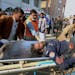 Workers and volunteers carry an injured victim of a suicide bombing upon arrival at a hospital in Peshawar, Pakistan, Monday, Jan. 30, 2023. 