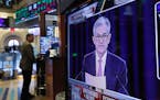 In this June 19, 2019, file photo the Washington news conference of Federal Reserve Chair Jerome Powell appears on television screen on the trading fl