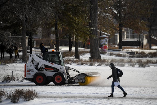 Power brooms and brushes, such as this one at the University of Minnesota Minneapolis campus in 2017, clear snow before it melts and are one tool to r