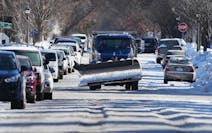 A snow plow navigates crowded, snow and ice covered Charles Ave. near Grotto St. N. Monday, Jan. 30, 2023 in St. Paul, Minn. 
