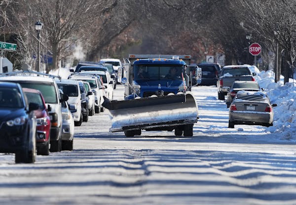 A snowplow navigates crowded, snow- and ice-covered Charles Avenue near Grotto Street in St. Paul on Monday.