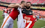Kansas City Chiefs tight end Travis Kelce, left, plants a kiss on the cheek of his brother, Philadelphia Eagles center Jason Kelce as they exchanged j