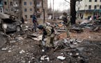 Ukrainian security forces comb through debris shortly after a strike at a residential building in Konstantanivka, Ukraine on Saturday, Jan. 28, 2023. 