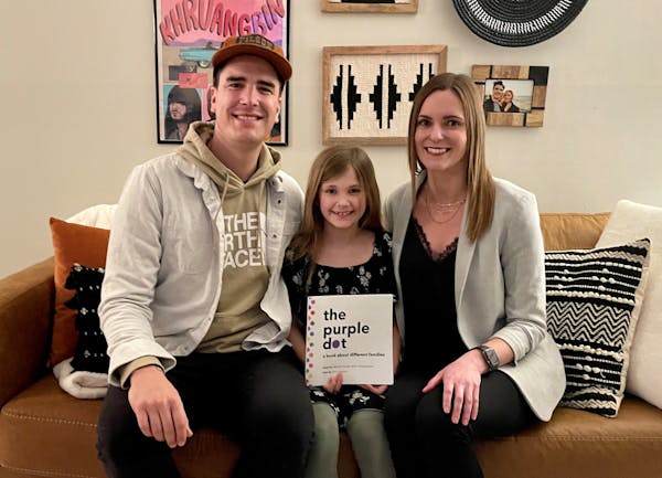 Reming Axelson, 8, (center) wrote “The Purple Dot” with the help of her father (left) Chris Axelson and bonus mom Olivia Larson.