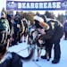 Keith Aili of Ray, Minn. greeted his dog team after they crossed the finish line to win the 39th annual John Beargrease Sled Dog Marathon on Tuesday a