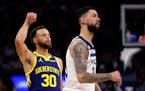 Golden State Warriors guard Stephen Curry (30) watches his 3-point basket, next to Minnesota Timberwolves guard Austin Rivers during the fourth quarte