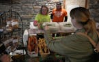 Pam Benike, left, and her son Isaiah work their Prairie Hallow Farms booth at the Mill City Farmers Market in Minneapolis on Saturday, Jan. 21, 2023. 