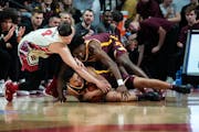 Rutgers’ Paul Mulcahy, left, fought for control of the ball with the Gophers’ Taurus Samuels, below, and Joshua Ola-Joseph during the first half o