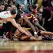 Rutgers’ Paul Mulcahy, left, fought for control of the ball with the Gophers’ Taurus Samuels, below, and Joshua Ola-Joseph during the first half o