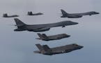 In this photo provided by South Korean Defense Ministry, U.S. Air Force B-1B bombers, center, F-22 fighter jets and South Korean Air Force F-35 fighte