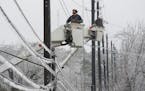 Austin Energy linemen Ken Gray, left, and Chad Sefcik work to restore power on ice-covered lines along West Alpine Road during a winter storm, Wednesd