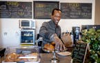Uganda native Ian Oundo works behind the counter of his newly opened coffee shop, Rafiki Coffee & Cafe, in St. Paul. The African Development Center an