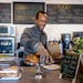 Uganda native Ian Oundo works behind the counter of his newly opened coffee shop, Rafiki Coffee & Cafe, in St. Paul. The African Development Center an