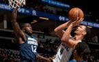 Jalen Suggs (4) of the Orlando Magic attempts a shot while defended by Taurean Prince (12) of the Minnesota Timberwolves in the first quarter, Monday,