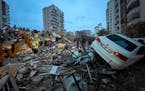 Emergency teams search for people in a destroyed building in Adana, Turkey, Monday, Feb. 6, 2023. A powerful quake has knocked down multiple buildings
