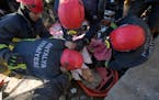 Rescue teams evacuate a survivor from the rubble of a destroyed building in Kahramanmaras, southern Turkey, Tuesday, Feb. 7, 2023.