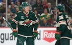 Minnesota Wild left wing Kirill Kaprizov (97), left, and right wing Mats Zuccarello (36) talk during the first period of an NHL hockey game against th