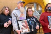 Jason Lange, with wife Kim Gustavson during a rally Tuesday at the State Capitol, held a photo of his stepson Travis Gustavson, who died of an overdos