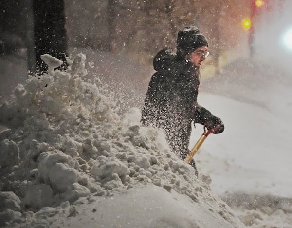 Brian Hedberg clears snow from the alleyway along 36th St. S., in order to try and get his car through a plowed snow bank Thursday, Feb. 23, 2023 in M