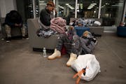 Kendrah Maki, left of center, and Darius Porter, relaxed out of reach of the winter storm at Catholic Charities’ St. Paul Opportunity Center’s tem