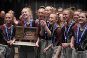 Gymnasts from New Prague celebrate after winning first place in the Minnesota State High School League Class 2A gymnastics championships Friday, Feb. 