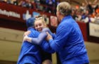 Reagan Kelley celebrated with her coaches Saturday at the Class 1A gymnastics state meet.