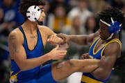 Jericho Cooper of Hastings, left, dealt with Bryon Sauvy of St. Michael-Albertville on his way to a 14-8 victory in their 182-pound match. 